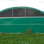 Un grand abri agricole avec filet brise vent