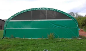 Un grand abri agricole avec filet brise vent