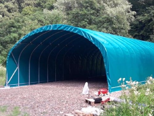 Abri agricole professionnel après montage, équipé d'une bâche camion verte